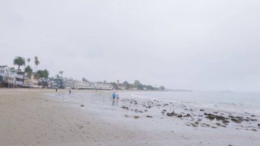Kaliforniya, Miramar Sahili kıyılarında yürürken bulutlu kış gökyüzü sakin ve yansıtıcı bir atmosfer yaratır..