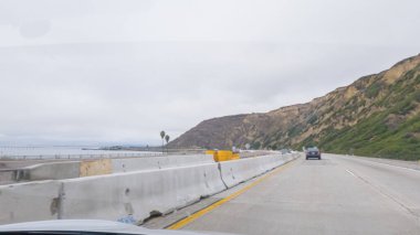 Kederli, bulutlu bir kış gününde, California, Rincon Sahili yakınlarında 101. Otoyol 'da araba sürüyorum..