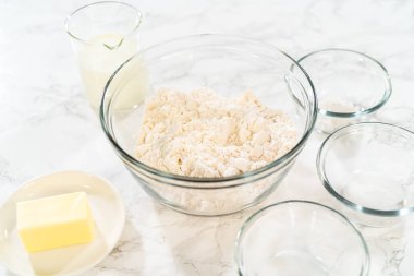 Bardaktaki ölçülü malzemeler mayasız tarçınlı kek pişirmek için karıştırılmış kaseler..