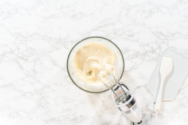 Düz yatıyordu. Lezzetli bir ikram yaratmak için, ev yapımı krem peynir kreması yapma süreci mükemmel bir doku ve tat elde etmek için kremalı malzemeleri çırpmayı içerir..