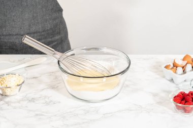 Bir çırpma makinesiyle, ölçülen malzemeler bir araya gelir. Pasta hamurunu bu lezzetli keke hazırlamak için ustalıkla karıştırılır..