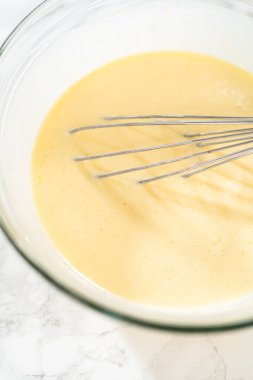 Bir çırpma makinesiyle, ölçülen malzemeler bir araya gelir. Pasta hamurunu bu lezzetli keke hazırlamak için ustalıkla karıştırılır..