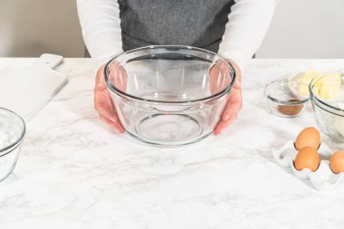 Büyük bir cam kasede, malzemeler harika havuçlu kek pişirmek için ustalıkla karıştırılır..