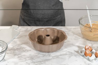 Silikon bir fırça kullanarak, metal demet kek tavası eritilmiş sebze kısaltmasıyla yağlanır, nefis havuçlu kek pişirmeye hazırlanır..