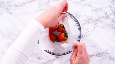 Düz yatıyordu. Çilekler, yeni yıkanmış ve kurutulmuş, cam bir kasede güzelce depolanmış kağıt havluyla kaplanmış ve tazeliği korumak için plastikle kaplanmış..