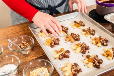 Çikolataya batırılmış ve fındık ezmesi ile süslenmiş kar tanesi şeklindeki kesme şekerli kurabiyeler yaratmak. Parşömen üzerinde zarif bir şekilde sunulmuş..