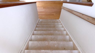 Ev tadilatı projesinin ortasında yakalanan bu merdiven yeni döşemeler için hazırlanıyor. Geçiş sürecini ve yenilenme vaadini simgeliyor..