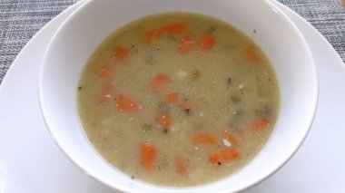 Yumuşak havuç ve bezelyelerle süslenmiş rahatlatıcı bir kase tavuk ve pirinç çorbası besleyici bir yemek için mükemmel bir ev yapımı lezzet sunar..