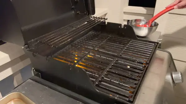当红色硅胶刷扫过烤架烤架时 准备好的烤架表面正在等待着 这是预热和清洁过程中必不可少的一步 以确保烹调体验均匀 — 图库照片