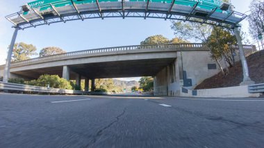 Kış günü San Luis Obispo, Kaliforniya yakınlarındaki ikonik 1. Otoyol boyunca bir araba gider. Çevresindeki manzara kahverengimsi ve bastırılmış, dalgalı tepeler ve kıyı şeritleriyle