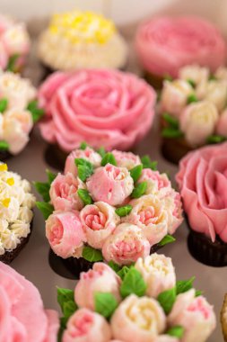 El değmemiş beyaz bir kek kutusunun içinde, her gurme kek bir sanat eseridir, tereyağı kremalı çiçeklerle süslenmiştir, canlı güllere ve lalelere benzemesi için güzelce tasarlanmıştır..