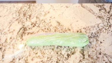 İyi ışıklandırılmış bir mutfakta, yeşil ve diğer renklerin çeşitli tonlarında tereyağlı krema çeşitleri büyüleyici kapkeklerin sanatsal dekorasyonu için titizlikle karıştırılıyor ve hazırlanıyor.