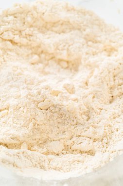 Kuru malzemelerle bardaktaki çırpma kabını karıştırıp mayasız tarçınlı kek pişirmek..