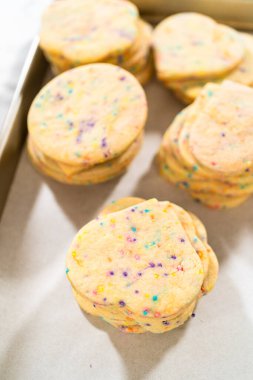 Büyük miktarda şekerli kurabiye düzgünce pişirme tepsisine istiflenmiş, paketlerinin kırsal kahverengi karton kutulara konmasını bekliyor..