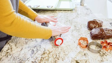 Modern bir mutfaktaki zarif mermer tezgahın üzerine zencefilli kurabiye hamuru sermek için ayarlanabilir bir merdane kullanmak, bayram pişirme şenliğine hazırlanmak....