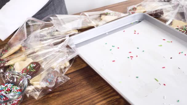Zorgvuldig Verpakken Van Kerstkoekjes Half Ondergedompeld Chocolade Gepresenteerd Heldere Cellofaan — Stockvideo
