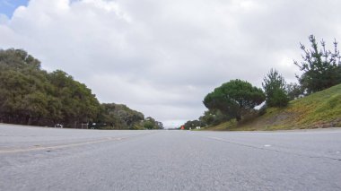 Araç, bulutlu bir kış gününde Morro Bay, Kaliforniya sokaklarında yol alır. Hava karamsar ve sakin bulutlu gökyüzü büyüleyici binalara yumuşak bir ışık ve sessiz