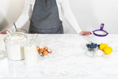 Cam kasenin içindeki malzemeleri birleştirmek, lezzetli bir vanilyalı kek hazırlamak için ustalıkla çırpmak..