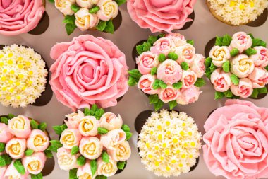 El değmemiş beyaz bir kek kutusunun içinde, her gurme kek bir sanat eseridir, tereyağı kremalı çiçeklerle süslenmiştir, canlı güllere ve lalelere benzemesi için güzelce tasarlanmıştır..