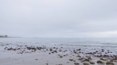 Kaliforniya, Miramar Sahili kıyılarında yürürken bulutlu kış gökyüzü sakin ve yansıtıcı bir atmosfer yaratır..