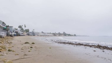 Kaliforniya, Miramar Sahili kıyılarında yürürken bulutlu kış gökyüzü sakin ve yansıtıcı bir atmosfer yaratır..