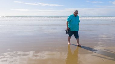 Baba ve kızı, güzel Pismo Sahili boyunca sakin ve çarpıcı dalgaların arka planında sakin bir kış yürüyüşünün keyfini çıkarıyorlar..