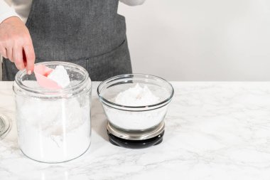 Ev yapımı krem peynir kreması için, pudra şekerini dikkatlice ölçmek zaruridir, tatlılığın ve kremalı dokuların mükemmel dengesini sağlar..