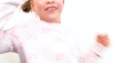 Neşeli bir anda, büyüleyici bir gülümseme ile büyüleyici küçük bir kız kameraya ışıldıyor, neşeli gökkuşağı renkli tellerini gösteriyor, bu da onun gençliğine ekstra bir parıltı katıyor.