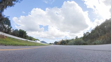 Açık bir kış gününde, bir araba, Santa Maria, California yakınlarındaki 101. Otoyol boyunca yeşil ve altın renkli bir karışımla çevrili, parlak mavi bir gökyüzünün altında sorunsuzca seyahat eder..