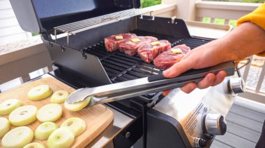 Açık hava gaz ızgarası iyi bir amaç için kullanılıyor. Pirzola bifteği ve soğan halkalarının sesi ve aromasıyla cızırdıyor..