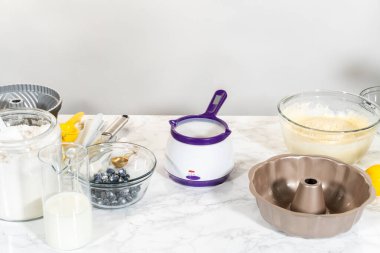 Kek kalıbı için yapışmaz bir yüzey oluşturmak için sebze kısaltma nazikçe eritilir ve unla harmanlanır..