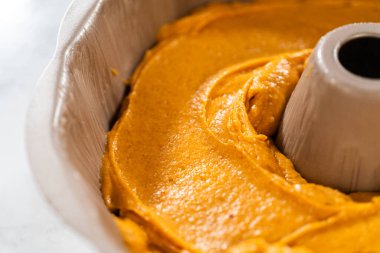 Pasta hamurunu kek tepsisine dökerek nefis bir ev yapımı balkabağı pastası yapmaya hazır..