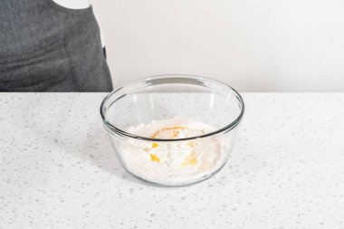 Büyük bir cam kasede ahşap bir kaşıkla karıştırılan malzemeler naan dippers pişirir..