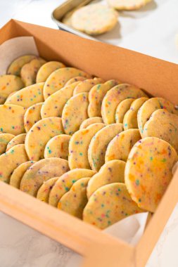 Hamurun içine şeker parçacıkları doldurulmuş olan kurabiyeler, özenle özenle hazırlanmış, kırsal kahverengi bir karton kutuya konur..