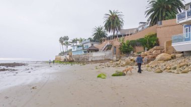 Los Angeles, California, ABD-4 Aralık 2022-POV-Yürürken Miramar Sahili, California kıyılarında bulutlu kış gökyüzü sakin ve yansıtıcı bir atmosfer yaratır..