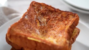 Çilek ezmesi ve pudra şekeriyle süslenmiş taze yapılmış Fransız tostu yığını..