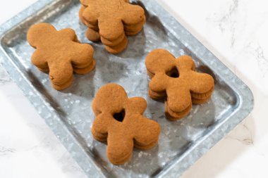 Zencefilli kurabiyeler, kalp şeklinde kesilmiş zencefilli bir adam, mermer bir tezgahın karşısında kırsal metal bir tepside dinleniyor..