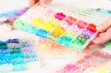 Beyaz bir masaya yerleştirilmiş çeşitli kil boncuk kutuları yaratıcı çocukların el sanatları projesini bekliyor..