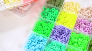 Renklere göre sıralanmış çeşitli kil boncukların yakın plan çekimleri, her boncuğu el yapımı ve mücevher yapımında eşsiz kılan desenleri ve desenleri vurguluyor..