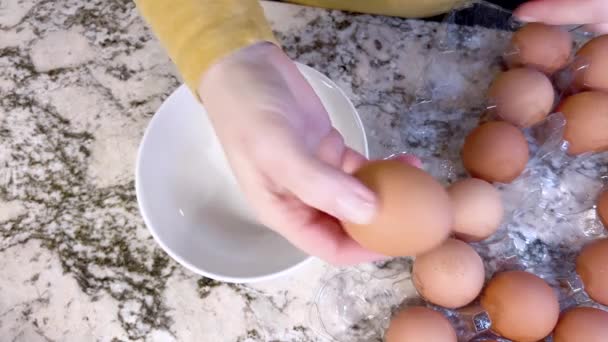 Показаны Руки Разбивающие Свежее Яйцо Над Белой Тарелкой Кучей Коричневых — стоковое видео