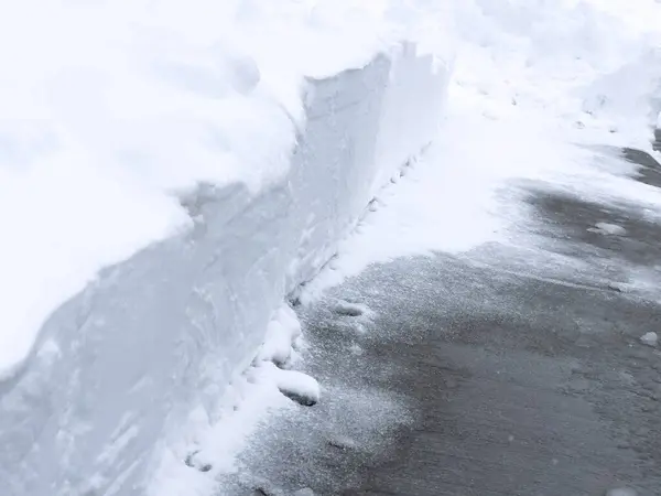 一条干净的铲过的人行道穿过厚厚的积雪 暴露了与原始的白色障碍物形成的鲜明对比 — 图库照片