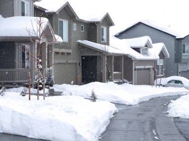 Castle Rock, Colorado, ABD-16 Mart 2024-Karlı Battaniyeler bir banliyö sokağı, evlerin durgun durduğu ve garaj yollarının sabah işçiliğinin kış aylarında aralıksız sürüklenmelere karşı olduğu.