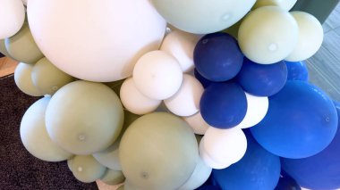 Mavi ve beyazın değişik tonlarında balonların sanatsal bir düzenlemesi, kutlamalar veya etkinlikler için ideal, tuhaf bir zemin oluşturur..