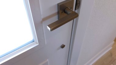 Gıcır gıcır beyaz bir kapıya monte edilmiş parlak siyah bir kapı kolu. Minimalist ve çağdaş bir ev tasarımını vurguluyor..