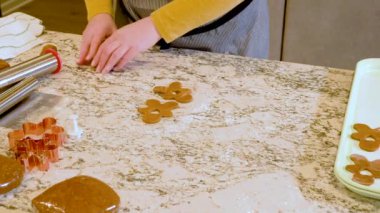 Çağdaş beyaz bir mutfakta zencefilli kurabiye hamuru ustalıkla sarılır ve nefis bir tatil ziyafeti için zemin hazırlar..