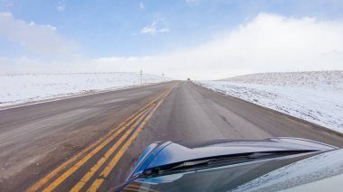 Kış sonrası fırtınada önden giden bir yol huzurlu bir sürüş sunuyor. Etrafı karla kaplı olan manzara, huzurlu ve resimsel çevreye katkıda bulunarak, sürüş gücünü artırıyor.