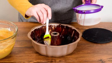 Carefully greasing a bundt cake pan in preparation for baking a delicious gingerbread bundt cake with caramel frosting. clipart