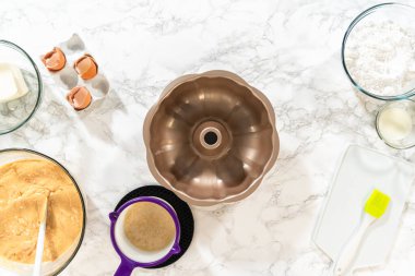 Silikon bir fırça kullanarak, metal demet kek tavası eritilmiş sebze kısaltmasıyla yağlanır, nefis havuçlu kek pişirmeye hazırlanır..