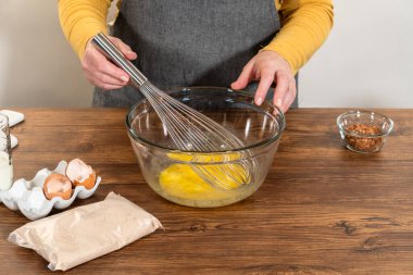 Bardak karıştırma kabında, büyük bir el çırpma ustalıkla lezzetli zencefilli kek ve karamel kremalı pasta malzemelerini karıştırır..