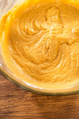 Bardak karıştırma kabında, büyük bir el çırpma ustalıkla lezzetli zencefilli kek ve karamel kremalı pasta malzemelerini karıştırır..